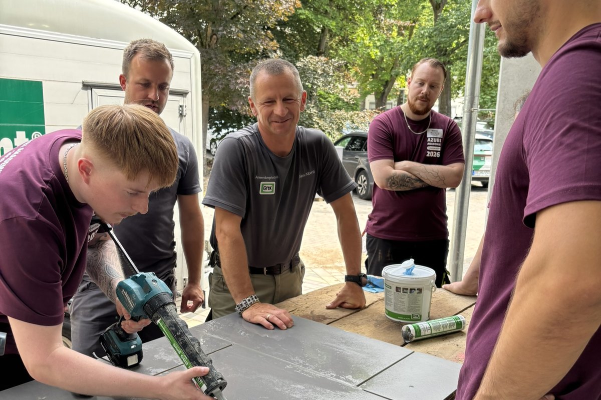 Teilnehmende des Hagebau Azubi-Camps schneiden unter Anleitung der GftK-Anwendungstechnik eine Platte zu.