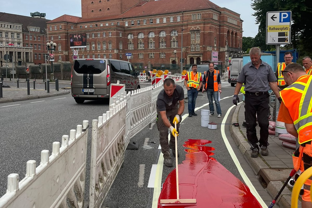 Application du revêtement rouge de piste cyclable devant l’hôtel de ville de Kiel.